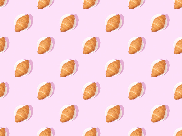 top view of croissants on plates on pink, seamless background pattern - Foto, Imagem