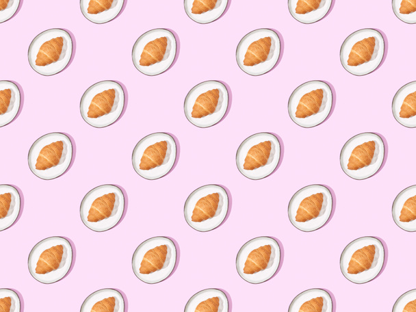 top view of croissants on plates on pink, seamless background pattern - 写真・画像