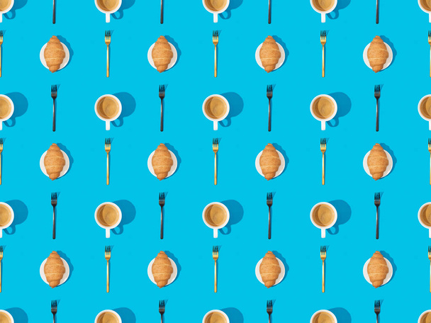 top view of cutlery, croissants on plates and coffee on blue, seamless background pattern - Photo, image