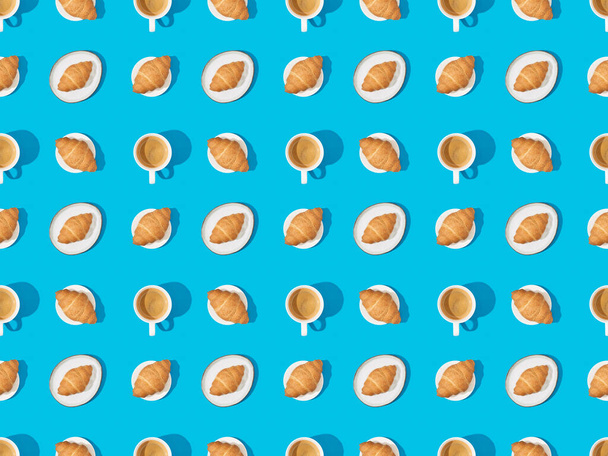 вид зверху на круасани на тарілках і каву на синьому, безшовному фоновому візерунку
 - Фото, зображення