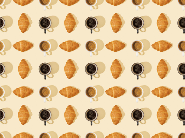 top view of croissants and coffee on beige, seamless background pattern - Foto, Imagen