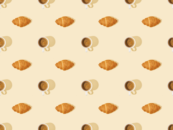 top view of croissants and coffee on beige, seamless background pattern - Foto, Imagem