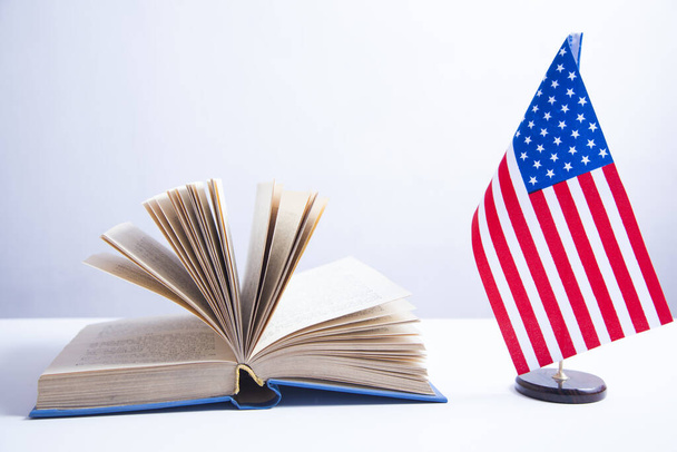 American flag on the stand and book on white background - Foto, Imagen