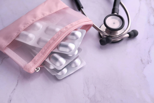 horní pohled na blistr balení, stetoskop a krabička pilulky na růžovém pozadí  - Fotografie, Obrázek