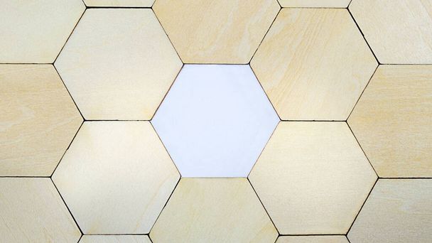 Wooden hexagon missing from a puzzle, revealing blank white paper with copyspace - Photo, Image