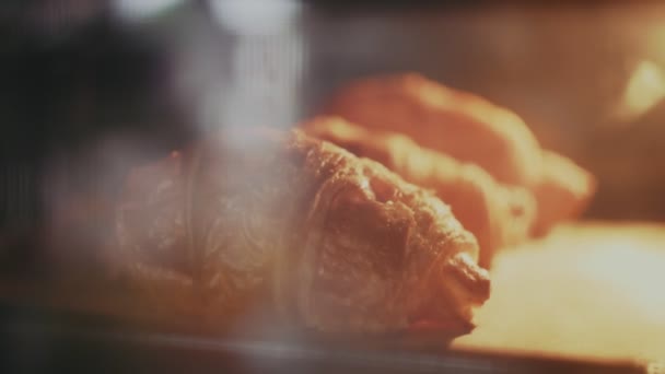 Κοντινό πλάνο νόστιμα και φρέσκα κρουασάν είναι στο δίσκο στο φούρνο - Πλάνα, βίντεο