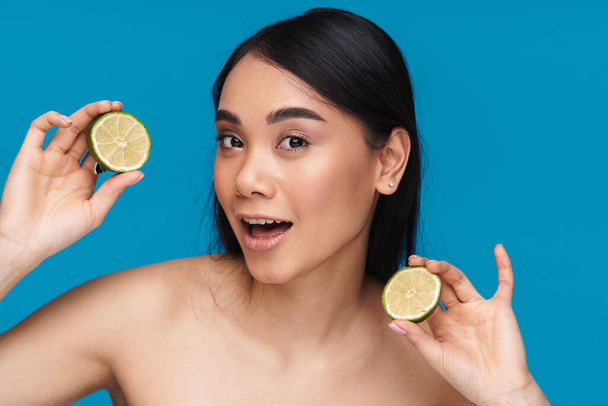 Photo of asian positive optimistic pretty young woman posing isolated over blue wall background with lime. - Photo, Image