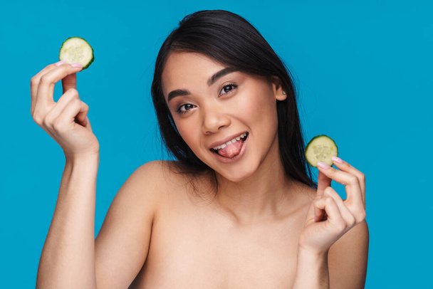 Photo of happy optimistic pretty young woman posing isolated over blue wall background with lime. - Zdjęcie, obraz