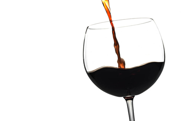 pouring red wine glass over a white background - Photo, Image