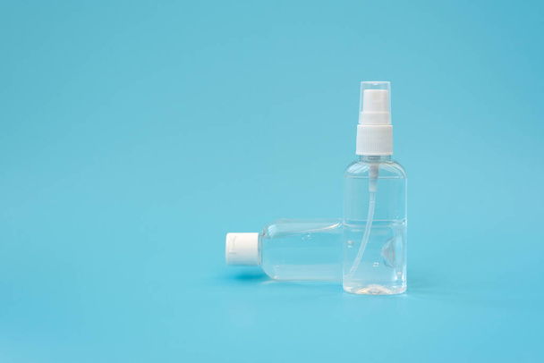 Set of antiseptic items. Bottles of antiseptic hand gel and spray on blue background. Flu, illness, pandemic concept - Photo, image