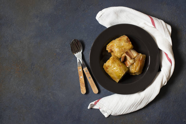 Sarma - traditional dish of Balkan cuisine. Cabbage rolls with meat and rice. Balkan cuisine. Serbian cuisine. Dark background. Top view. Space for text - Foto, Imagen