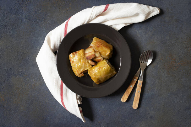 Sarma - traditional dish of Balkan cuisine. Cabbage rolls with meat and rice. Balkan cuisine. Serbian cuisine. Dark background. Top view. Space for text - 写真・画像