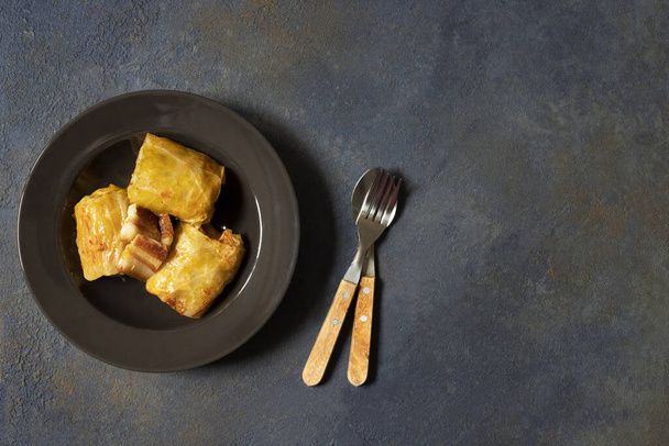 Sarma - traditional dish of Balkan cuisine. Cabbage rolls with meat and rice. Balkan cuisine. Serbian cuisine. Dark background. Top view. Space for text - Foto, imagen
