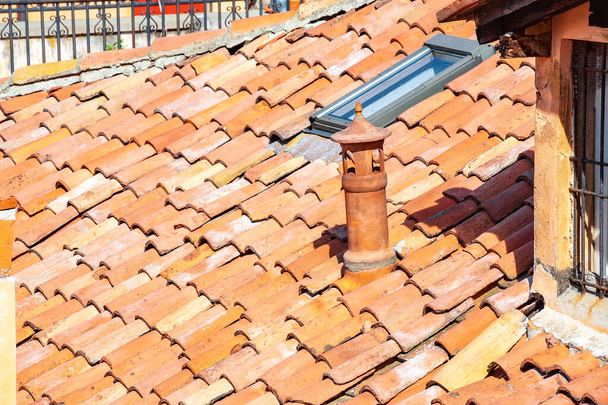 Chimney pipe and old ceramic shingles tile on the roof. - Photo, Image