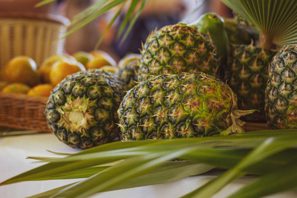 Colorful pineapples outdoors. Pineapple on the table. Juicy fruits. - Foto, immagini