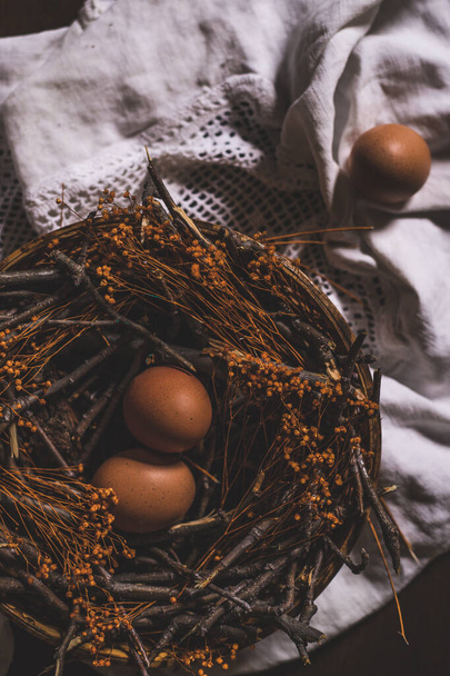 dos huevos en el nido y uno en la mesa
 - Foto, Imagen