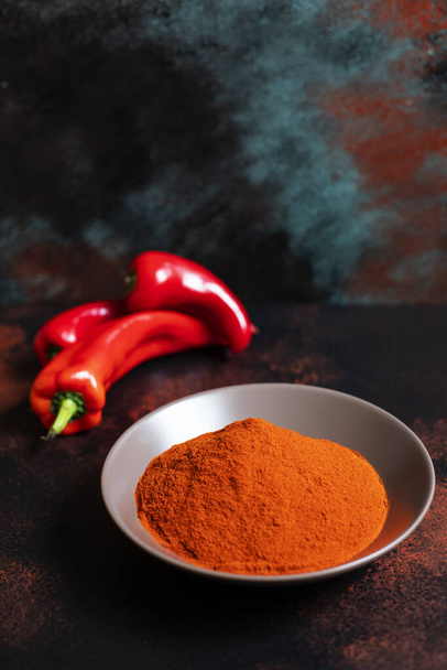Paprika powder in a plate on a colorful oriental background. Bright colours. Selective focus. Close-up - Fotoğraf, Görsel