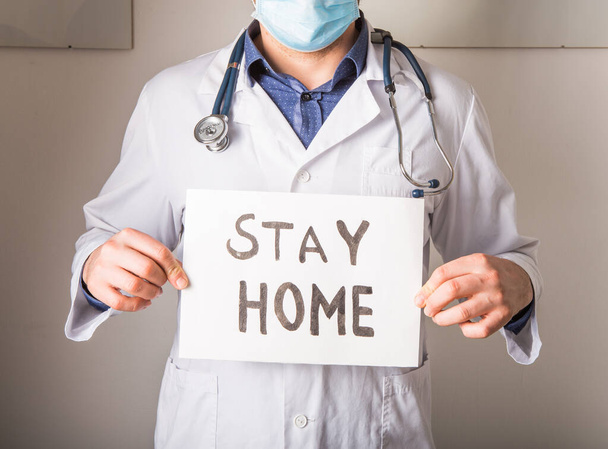 Doktor evde kal tabelasını tutuyor. Coronavirus 'la Savaşmak İçin Evde Kalın etiketi olan insanlara yalvarmak. Anti NCoV Covid-19 Virüsü - Fotoğraf, Görsel