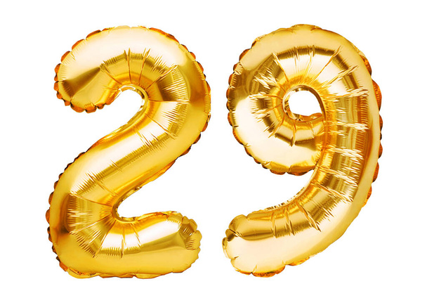 Numero 29 kaksikymmentäyhdeksän on tehty valkoisella eristetyistä ilmapalloista. Heliumilmapalloja, kultaisia folionumeroita. Juhlakoristelu, juhlakyltti lomille, juhla, syntymäpäivä, karnevaali
. - Valokuva, kuva