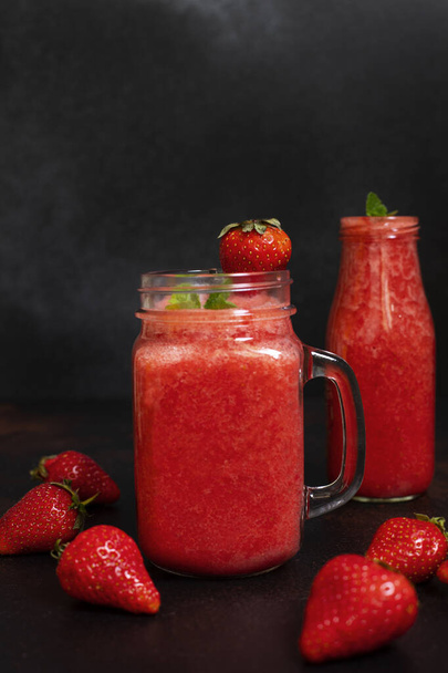 Batidos de fresa y fresas con hielo en frascos. Una refrescante bebida de verano. Vista de cerca. Copiar espacio - Foto, Imagen