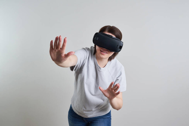 Mujer joven feliz jugando en gafas VR interior, concepto de realidad virtual con chica joven divirtiéndose con gafas de auriculares, con espacio para copiar
 - Foto, imagen