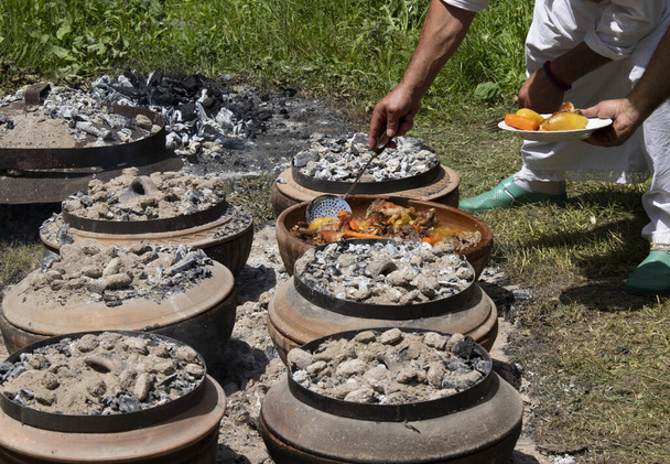 伝統的なバルカン料理,セルビア語,金属鍋や袋と呼ばれる金属蓋で野菜とトルコの子羊の肉,袋やサッシ.ストリートフード。フードフェスティバル。伝統的なバルカン料理 - 写真・画像