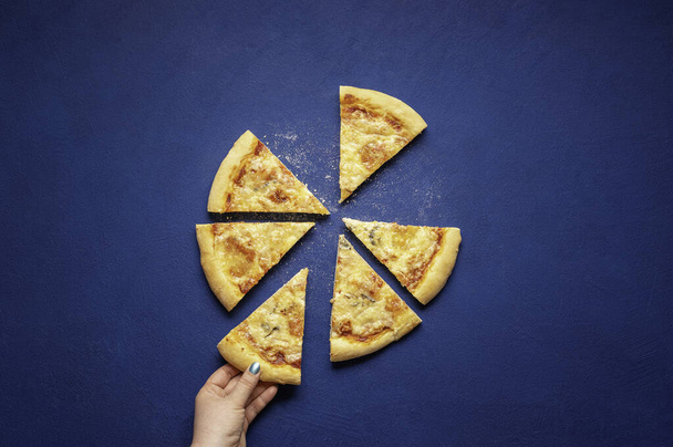 Pizza quattro formaggi dělal doma. Pizza nakrájená na modré pozadí, nad vyhlídkou. Italská pizza se 4 druhy sýrů. - Fotografie, Obrázek