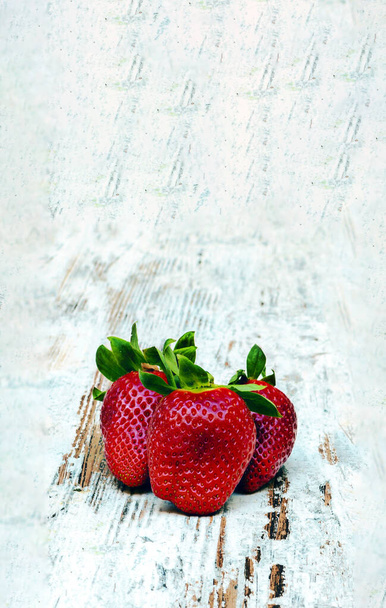 Aardbeien omgeven door rustieke achtergrond - Foto, afbeelding