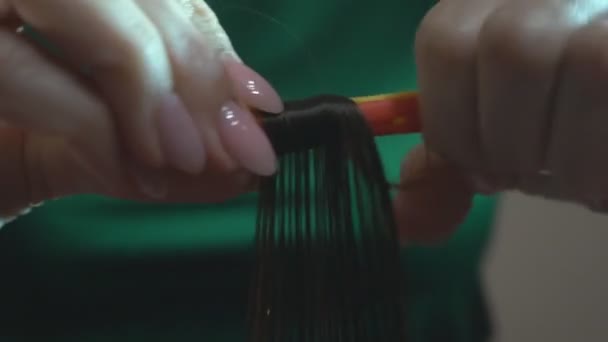 Lockenhaar auf der Locke. Der Friseur frisiert ein Kind, indem er die Haare in einem Schönheitssalon zu Locken kämmt und verdreht. - Filmmaterial, Video