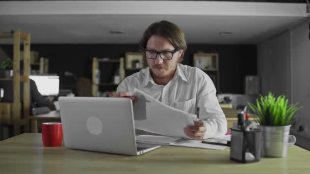 Junge Managerin schaut Unterlagen am Schreibtisch im Büro zu - Filmmaterial, Video
