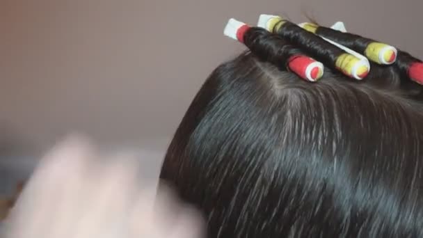 Kiharat kiharat. Kampaaja tekee kampauksen lapselle kampaamalla ja kiertämällä hiukset kiharaksi kauneushoitolassa.
. - Materiaali, video