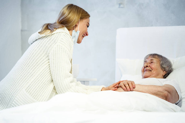 healthcare in hospital concept. daughter visiting old lady in hospital - Photo, image