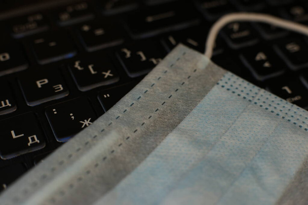 макро фото медицинская маска против вируса лежит на клавиатуре, карантин удаленной работы
 - Фото, изображение