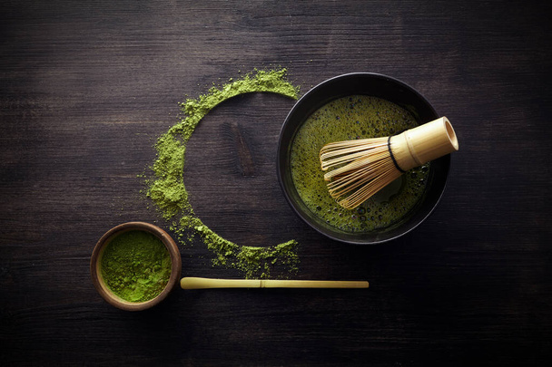 Matcha powder. Organic green matcha tea ceremony. Healthy drink. Traditional japanese drink on black wooden background - Fotó, kép