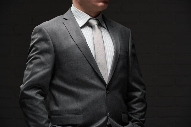 ritratto di uomo d'affari vestito in abito grigio, sfondo della parete scura
 - Foto, immagini