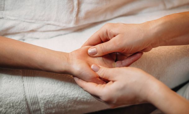 Close up photo of a hand massage session at a professional spa salon - Foto, afbeelding