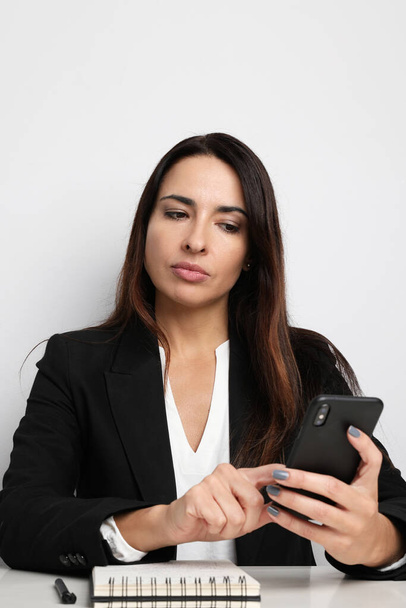 Business woman working in the office with her smartphone. Isolated. - Foto, imagen