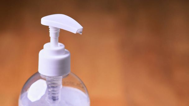 Una botella de plástico transparente blanco con gel desinfectante de manos transparente sobre un fondo de madera, concepto para coronavirus covid-19 e higiene de manos
 - Foto, imagen