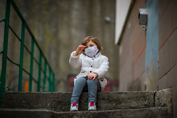 little girl on a walk in a medical mask - Фото, зображення