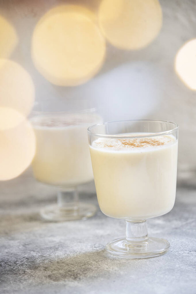 Eggnog traditional homemade Christmas and New Year drink with cinnamon and nutmeg. Winter holidays mood. Light background. Selective focus - Photo, Image