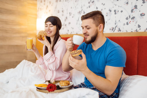 Romantic love couple, breakfast in bed at home, good morning, caring husband. Harmonious relationship in young family. Man and woman resting together in their house, carefree weekend - Foto, Imagem