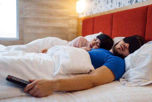 Amore coppia che dorme in copriocchi a letto a casa, sano sonno comfort. Rapporto armonioso nella giovane famiglia. Uomo e donna riposano insieme nella loro casa, fine settimana spensierato
 - Foto, immagini