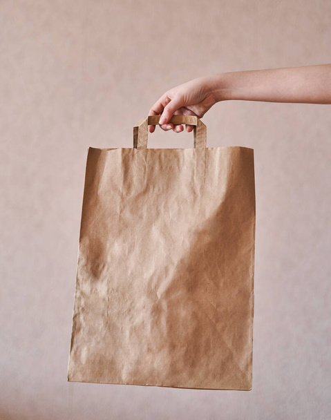 Girl holds an eco-friendly paper bag. Close-up - Fotografie, Obrázek