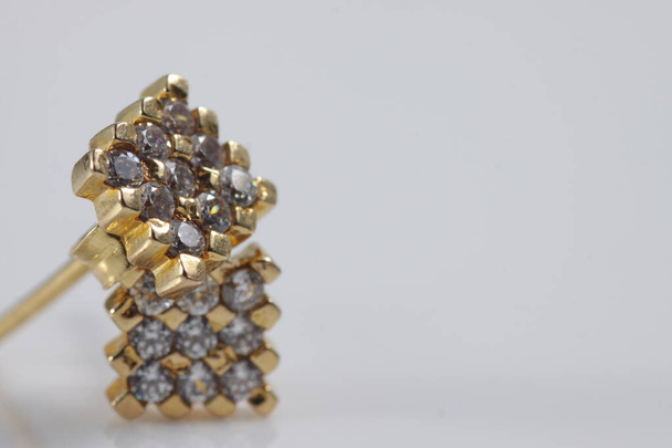 Macro tiro de anel de orelha de ouro quadrado em um fundo isolado
 - Foto, Imagem