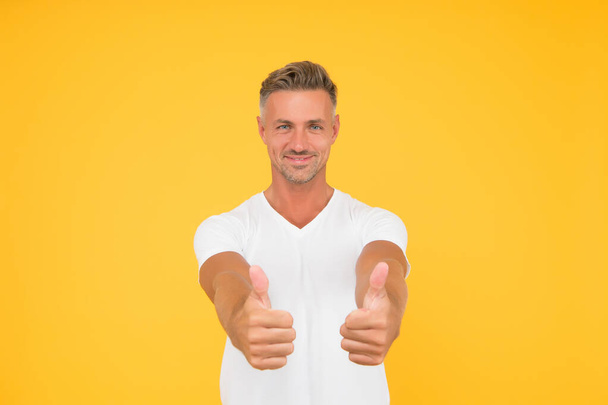 Approved. Happy man give thumbs ups yellow background. Promoting and approving. Promoting product. Sales promotion. Promoting and advertising. Personal selling. Advertising. Marketing and promoting - Photo, image
