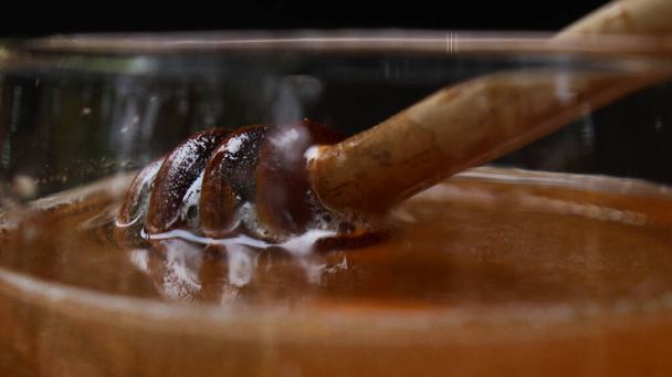 O mel é nutritivo para a saúde, conceitual com colher e favo de mel
 - Foto, Imagem