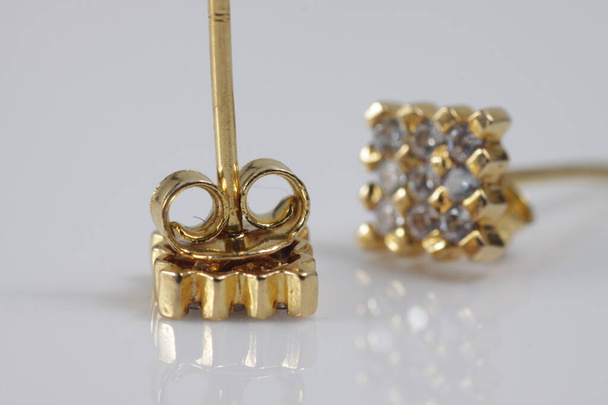 Macro tiro de anel de orelha de ouro quadrado em um fundo isolado
 - Foto, Imagem