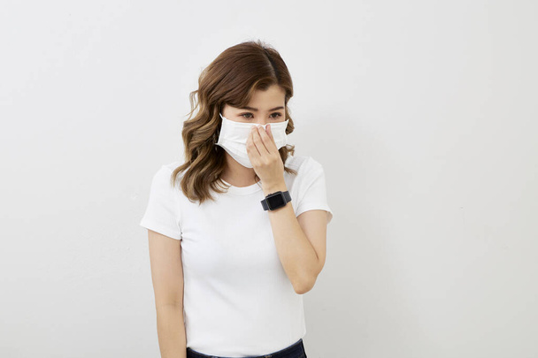 Молода азіатка в масці для обличчя ізольована на яскраво-сірому тлі. Епідемія грипу, пилова алергія, захист від вірусу. Концепція забруднення повітря міста
 - Фото, зображення
