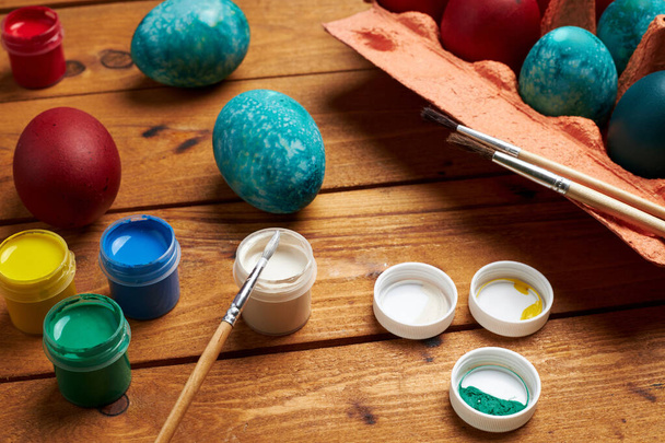 Painting eggs. Paints and brushes for coloring eggs for holiday. Preparing for Easter. - Foto, Bild