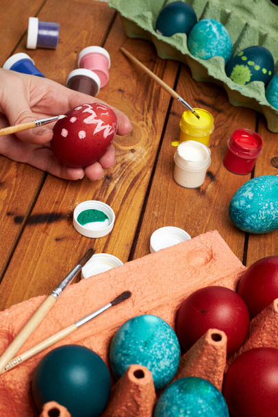 Painting eggs. Woman's hands paint eggs for Easter day. Preparing for Easter. - Zdjęcie, obraz